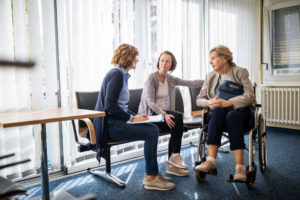 Caregiver discussing with women in waiting room