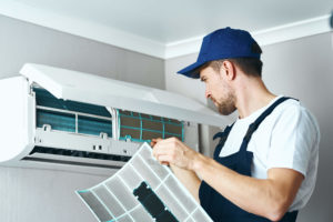 A hired worker repairman cleans and repairs the air conditioner