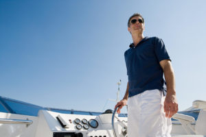 Man steering a yacht