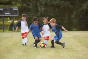 Children playing soccer outdoors