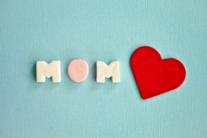 The word mom spelt in candy alongside a red love heart.