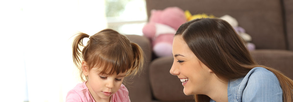 nanny and young girl playing with blocks