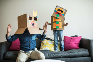 father playing with son. They have boxes on their heads