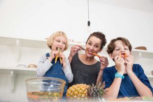 mother and children having fun with food